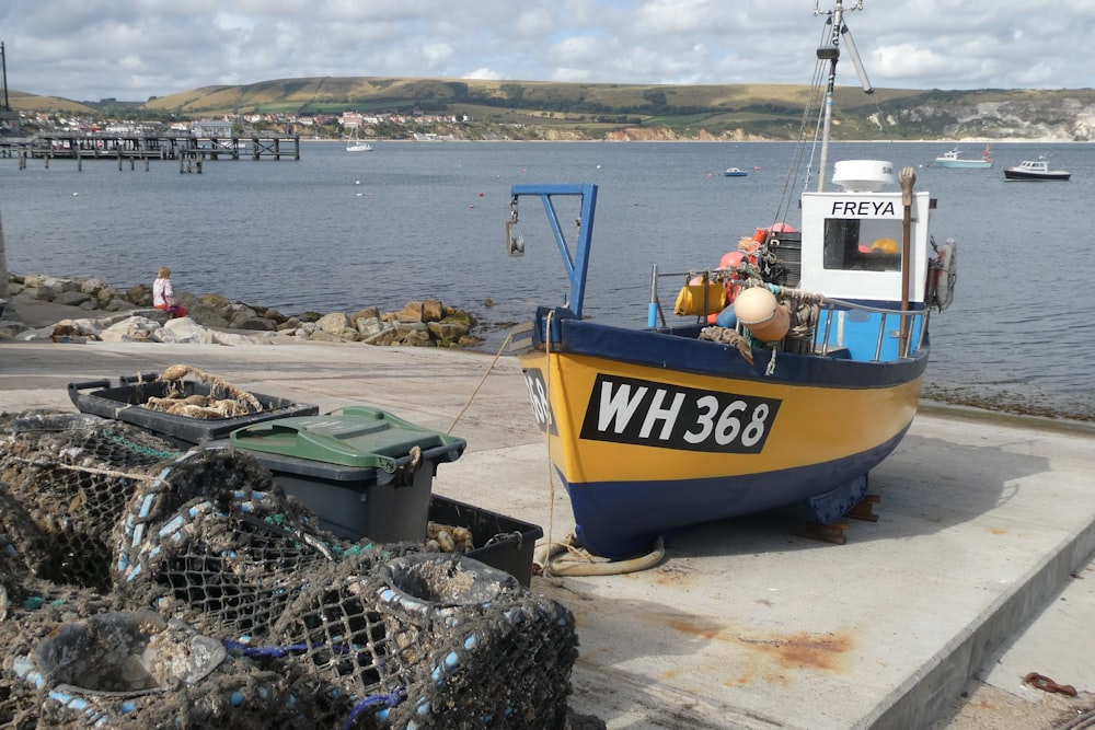 a yellow and blue boat sitting on top of a pier