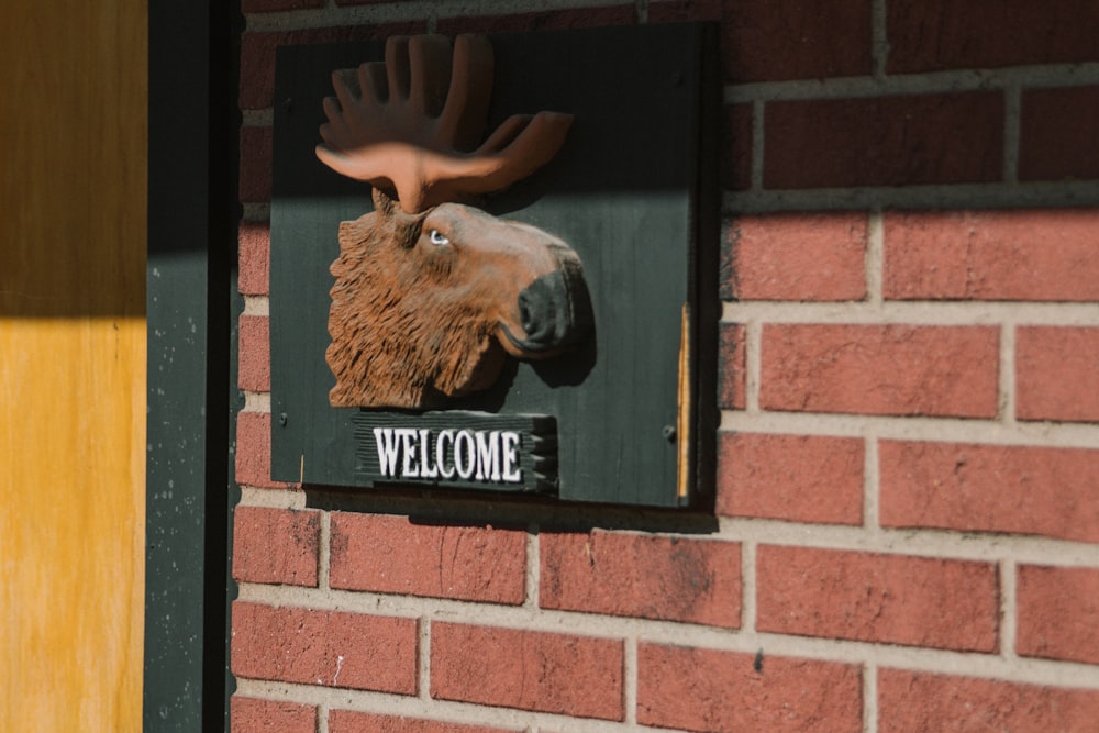a moose head mounted to the side of a brick building