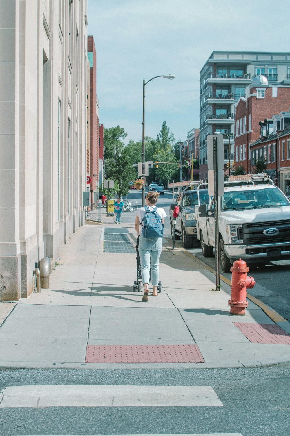 a man riding a skateboard down a sidewalk next to a red fire hydrant