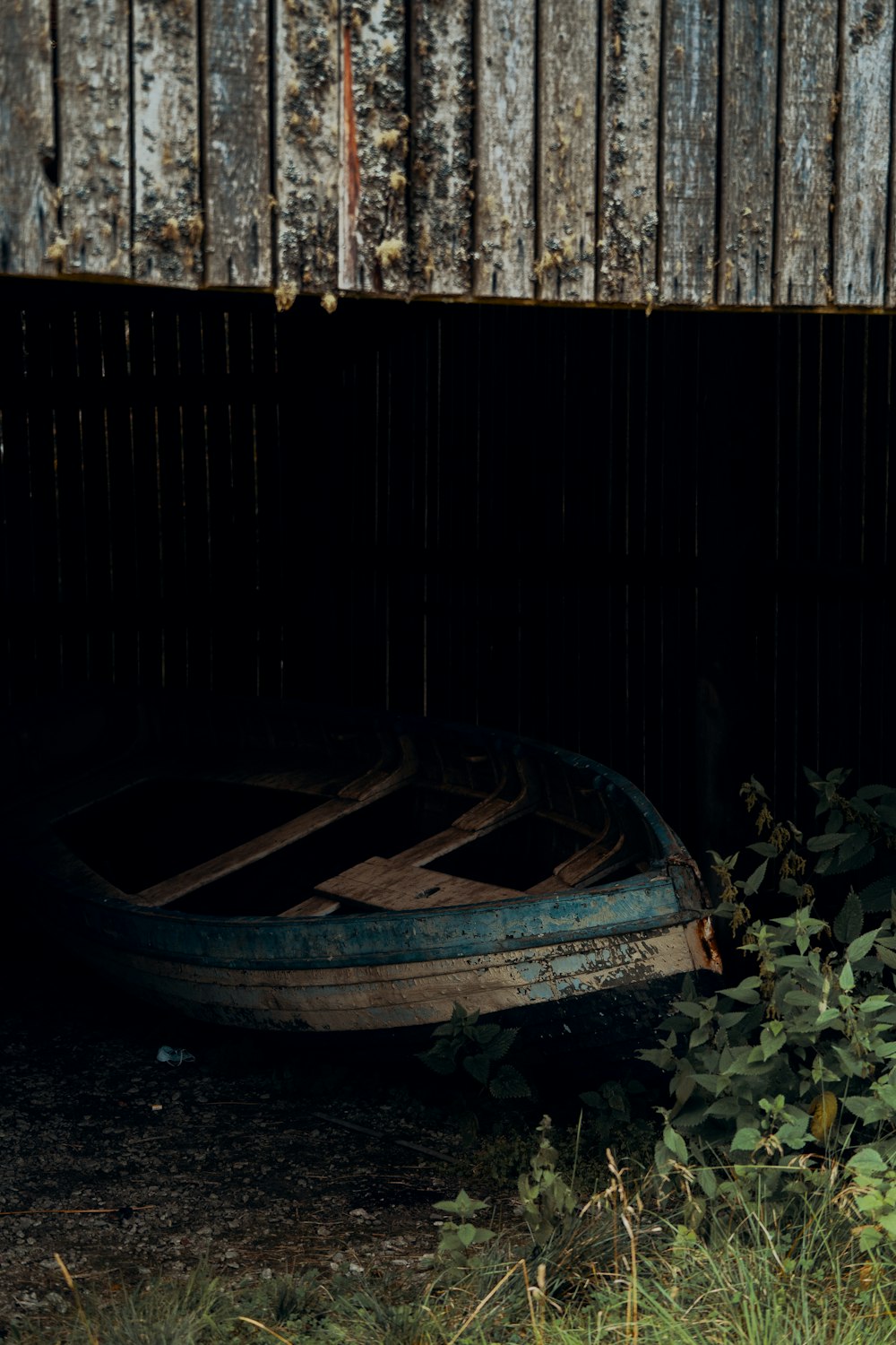 a boat sitting in the grass next to a building