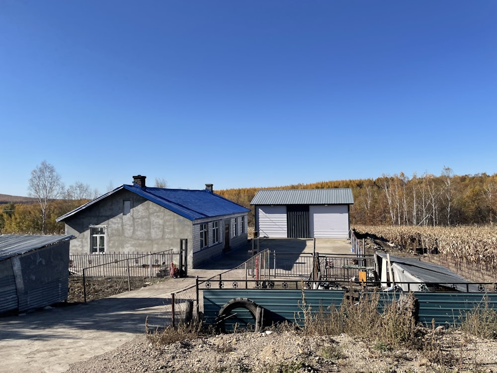 a house with a blue roof next to a field