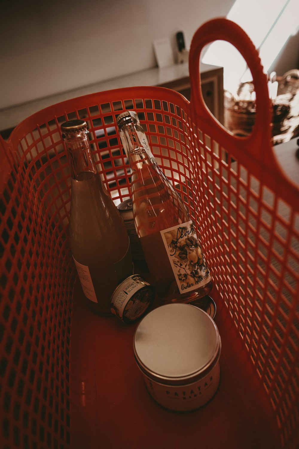 uma cesta vermelha cheia de garrafas de líquido