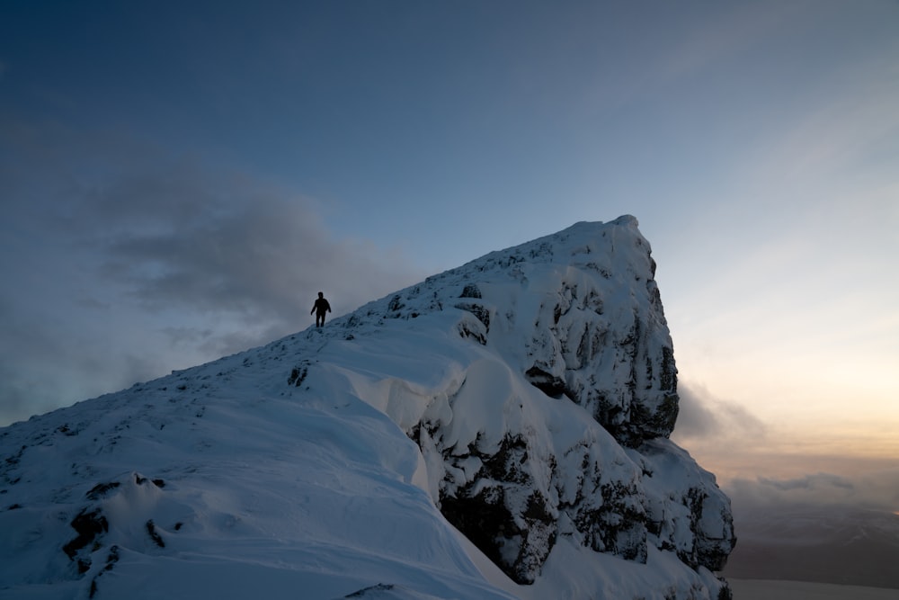 a man standing on top of a snow covered mountain