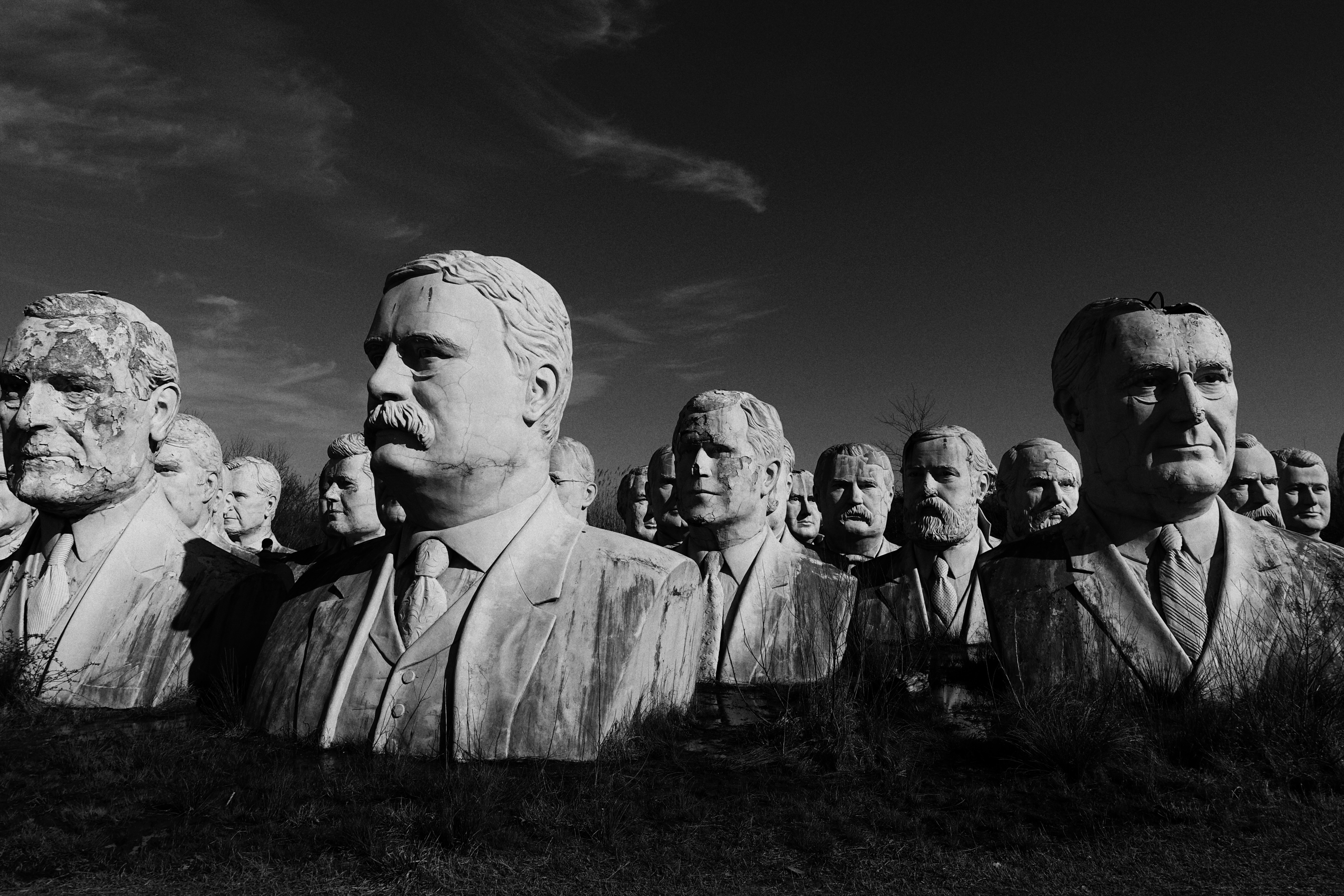 a black and white photo of a group of statues of men