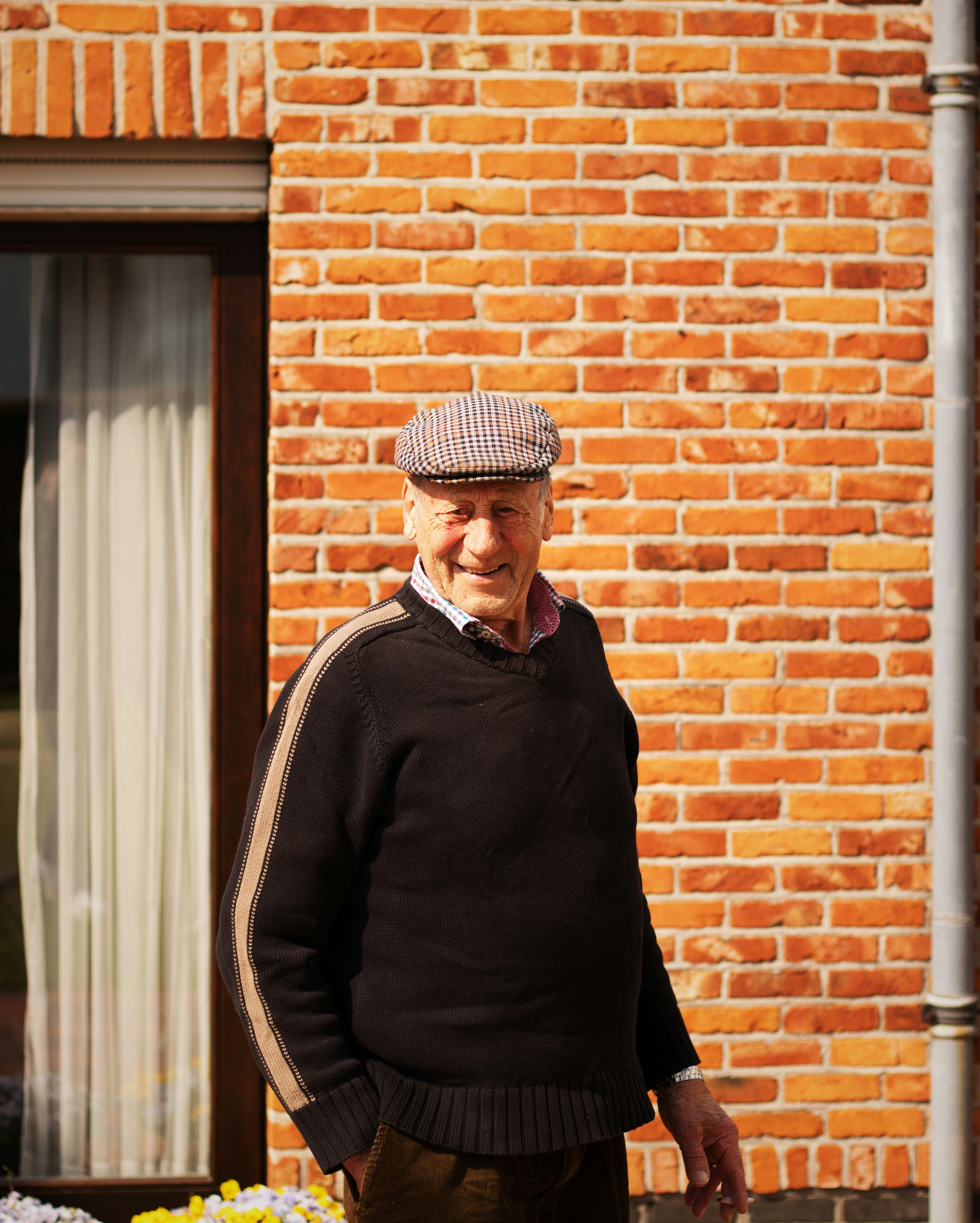 a man standing in front of a brick building