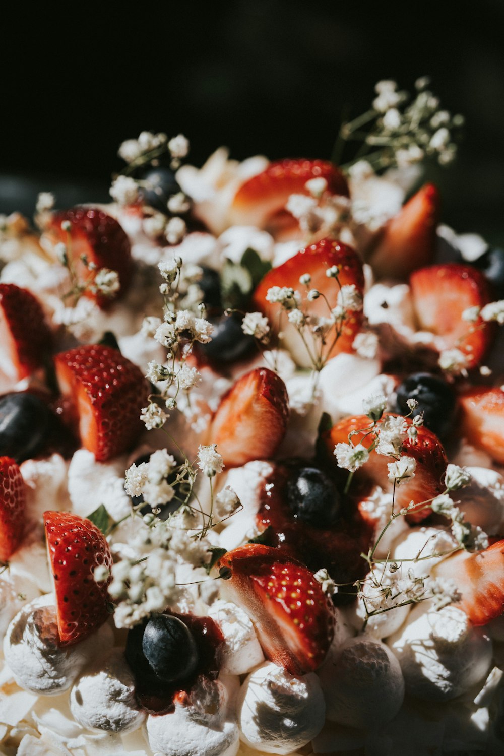 a close up of a cake with strawberries and blueberries