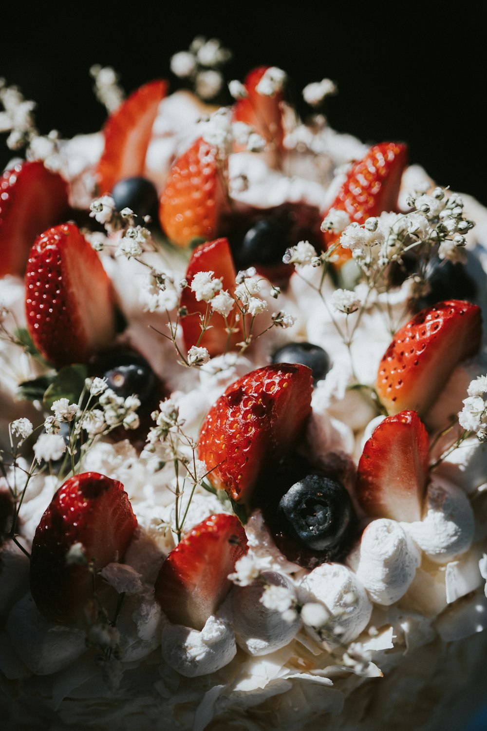 a close up of a cake with strawberries and blueberries
