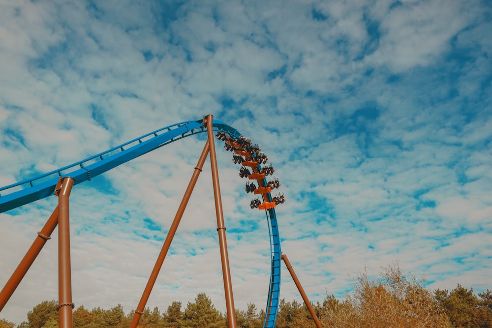 a roller coaster going down a hill on a cloudy day