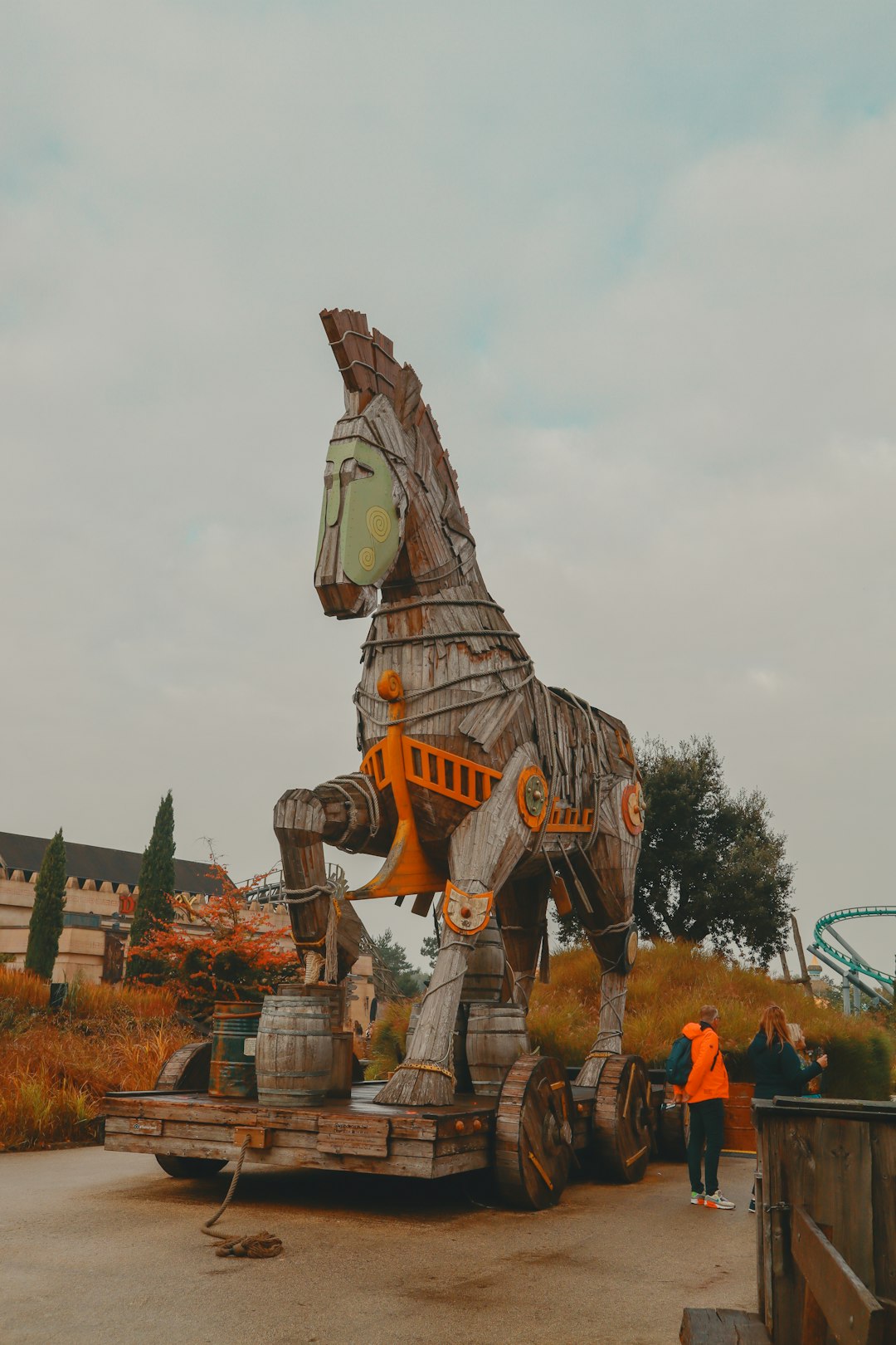 a large wooden horse statue sitting on top of a dirt field