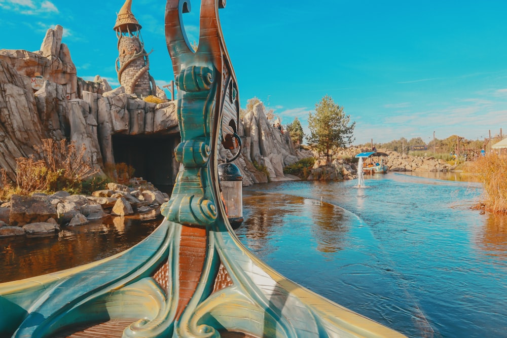 a boat traveling down a river next to a rock formation