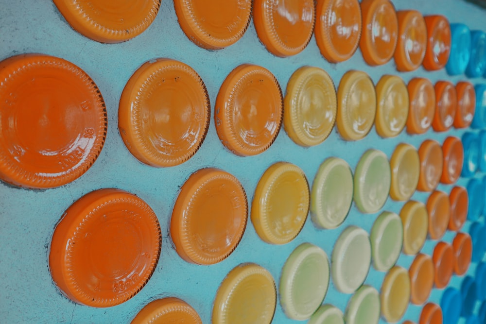 there are many orange and yellow plates on the wall