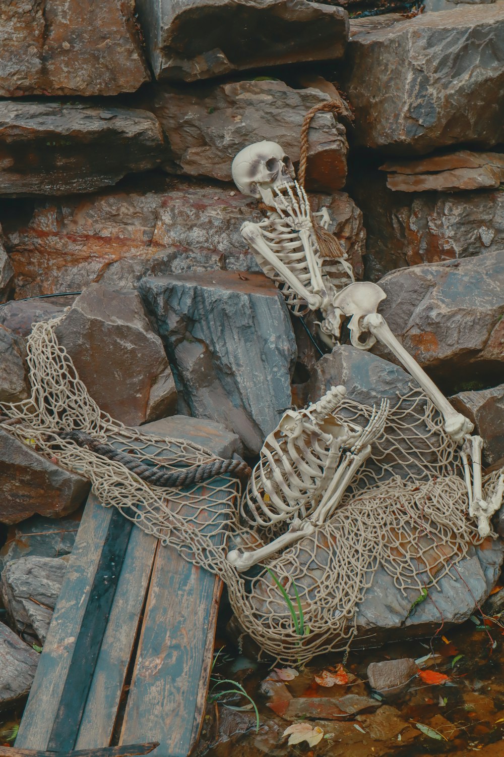 Un couple de squelettes assis au sommet d’un tas de pierres