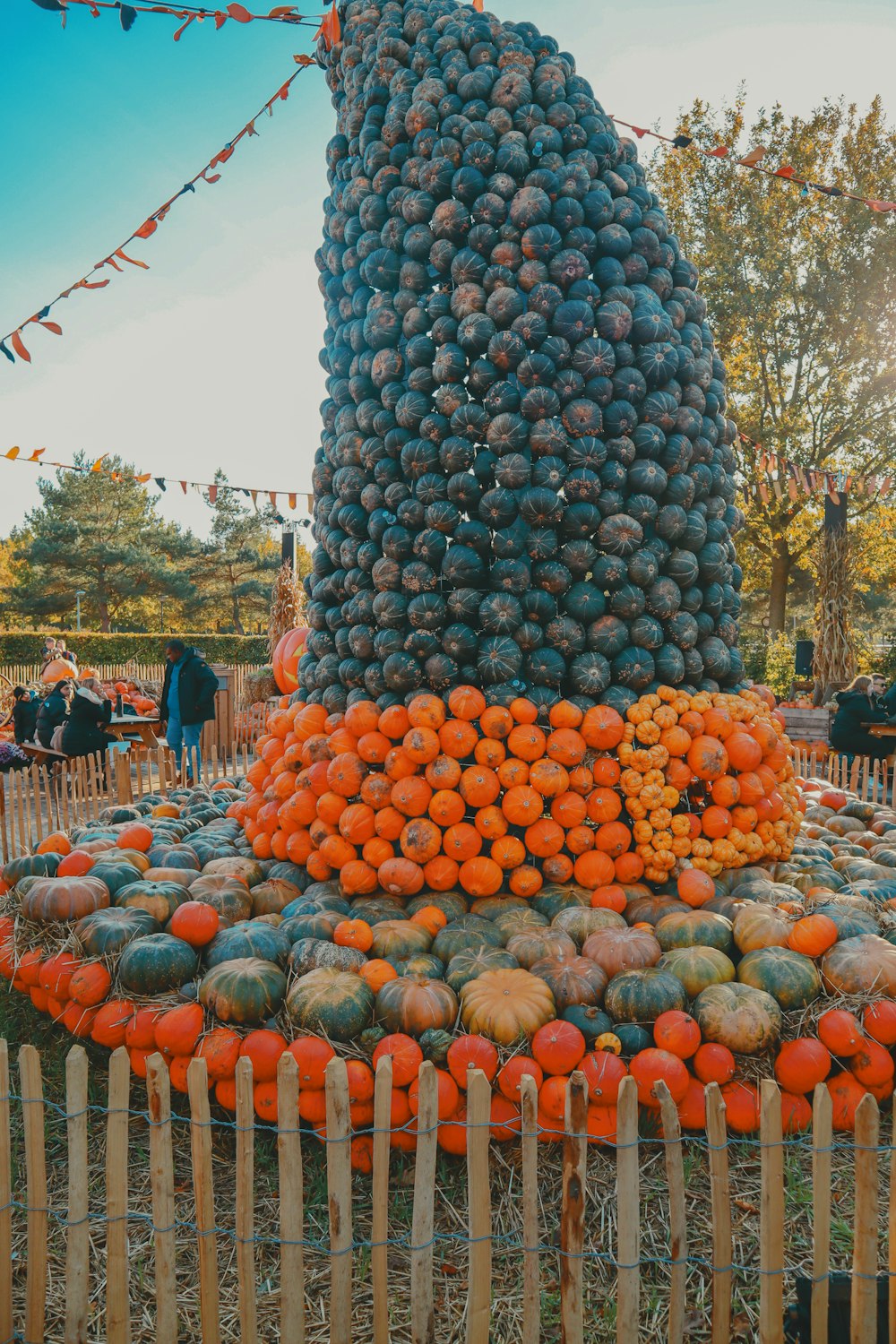 uma grande pilha de frutas sentada em cima de uma cerca de madeira