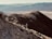 A hiker standing on a mountain trail with stunning views of the Andes.