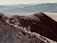 A hiker standing on a mountain trail with stunning views of the Andes.