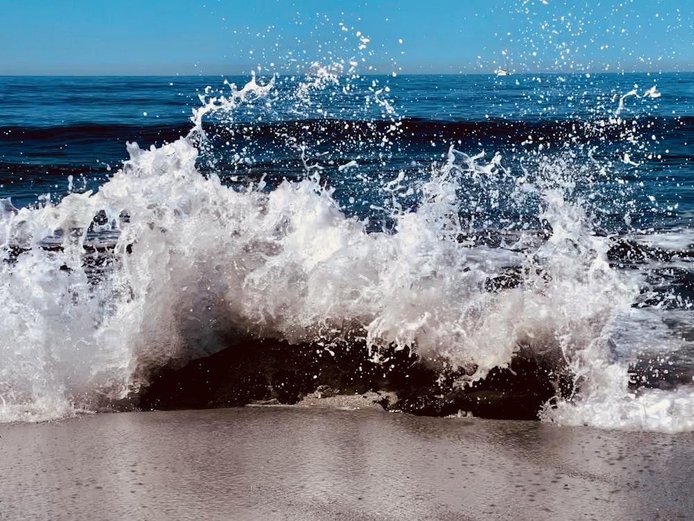 a wave crashes into the shore of a beach