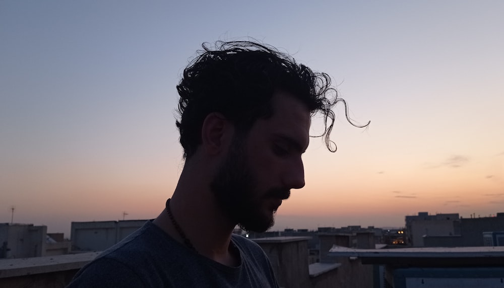 a man standing on top of a roof next to a tall building