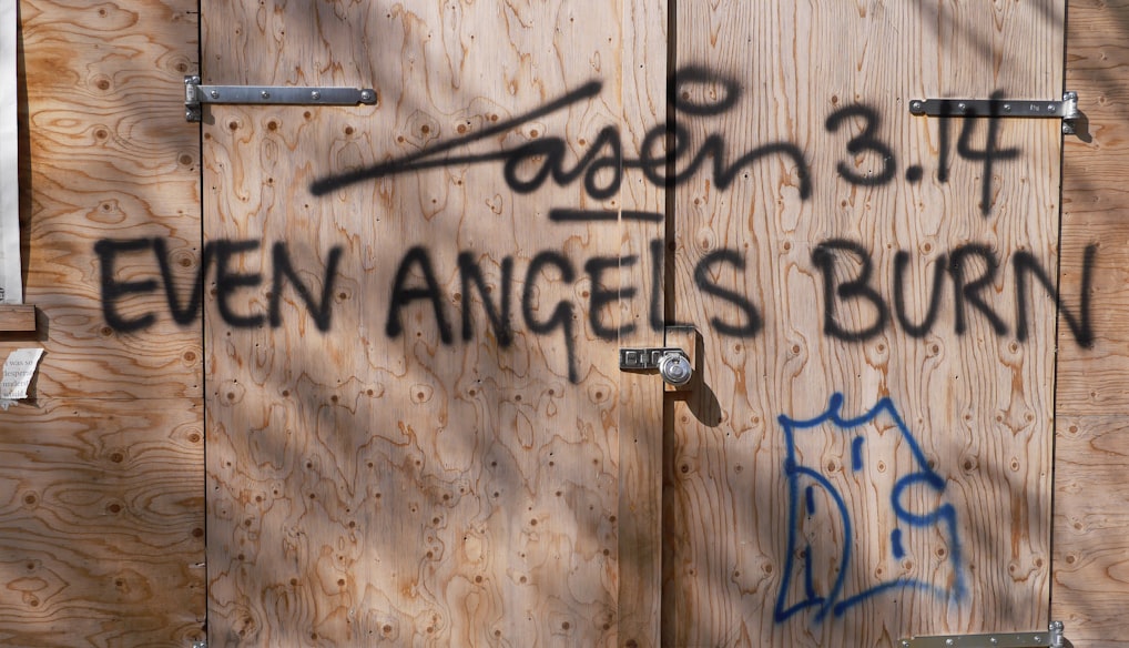 a wooden building with graffiti written on it