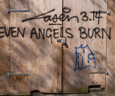 a wooden building with graffiti written on it