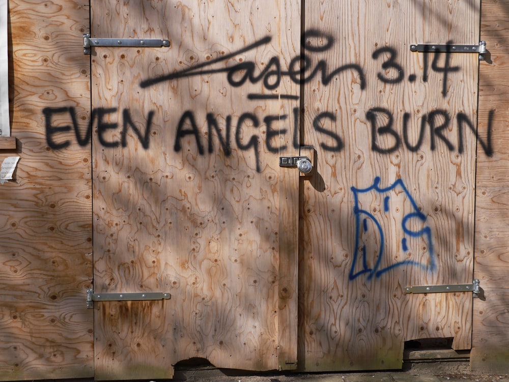 a wooden building with graffiti written on it