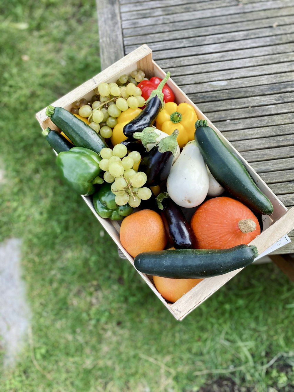 uma caixa de madeira cheia de frutas e legumes variados