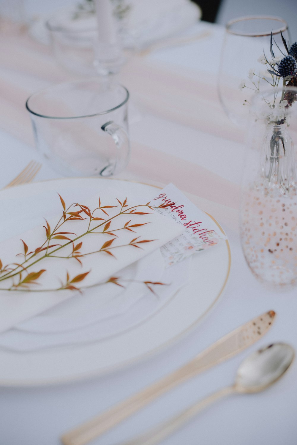 a table set with a white plate and silverware