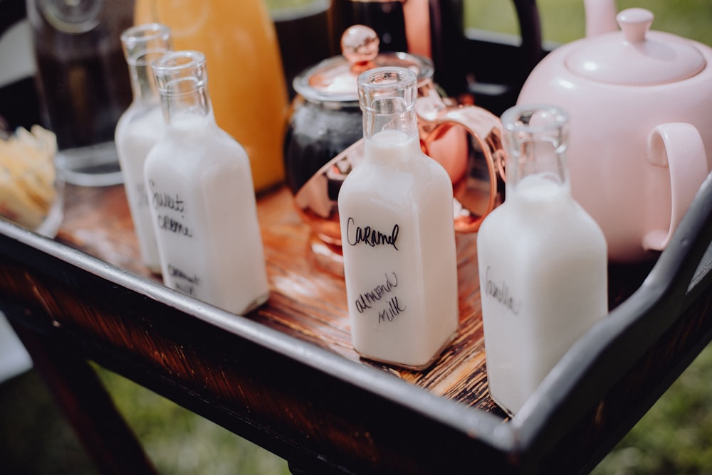 a wooden table topped with lots of bottles of milk