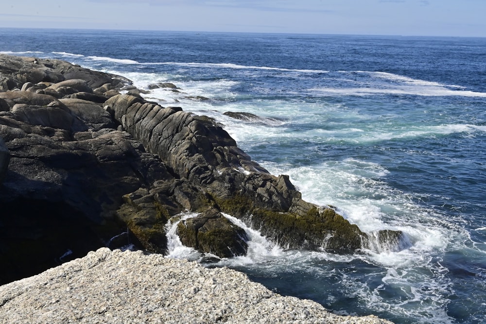 a rocky shore with waves crashing against the rocks