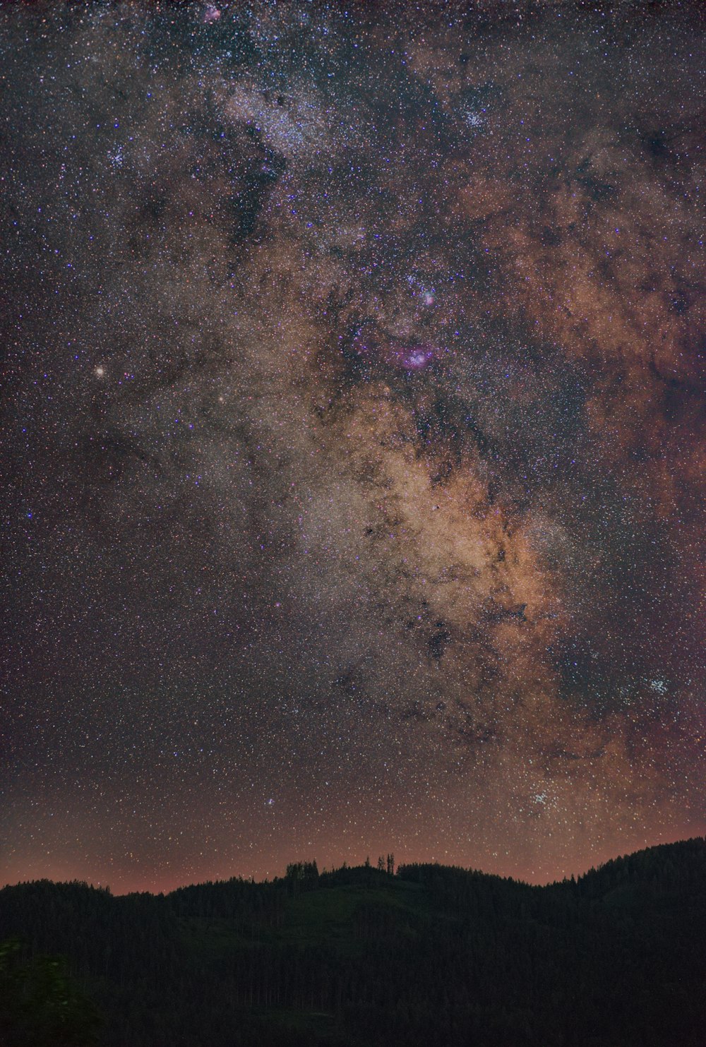 the night sky is filled with stars above a mountain