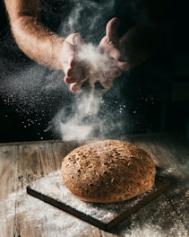 a loaf of bread being sprinkled with flour