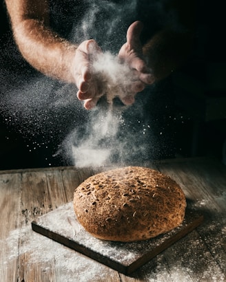 a loaf of bread being sprinkled with flour