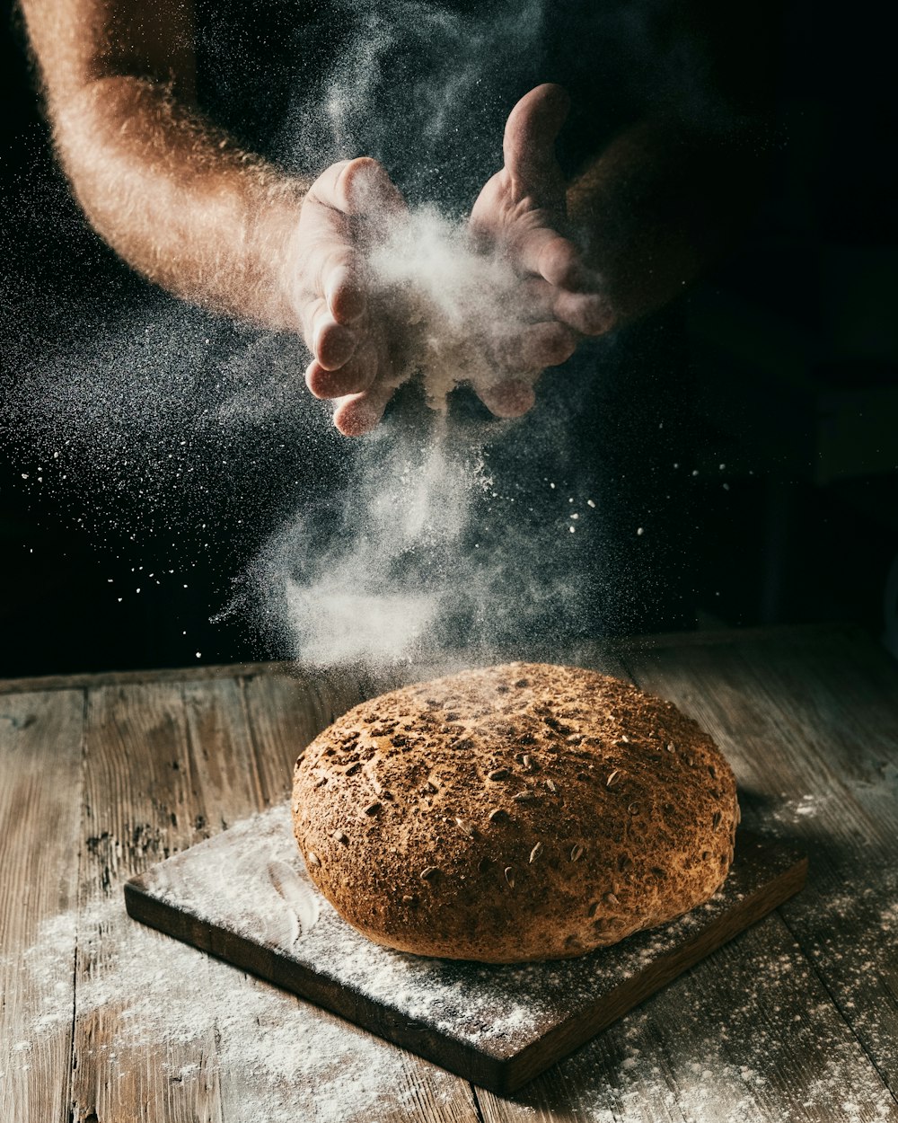 a loaf of bread being sprinkled with flour