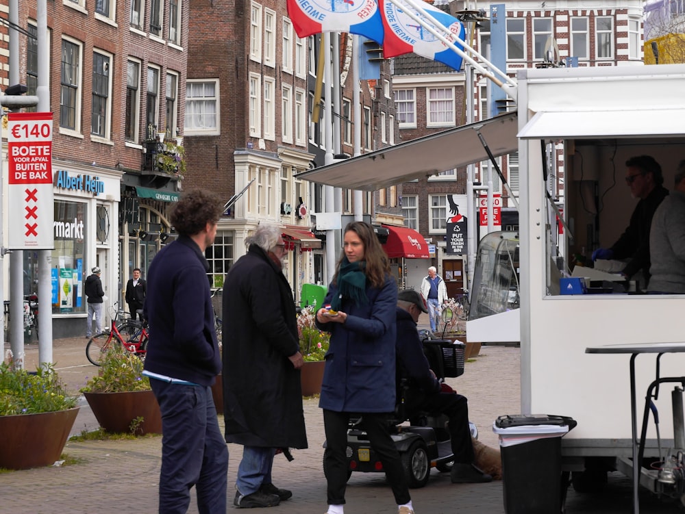 a group of people standing around a food truck