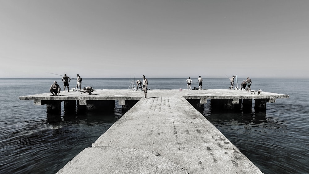 a group of people standing on top of a pier