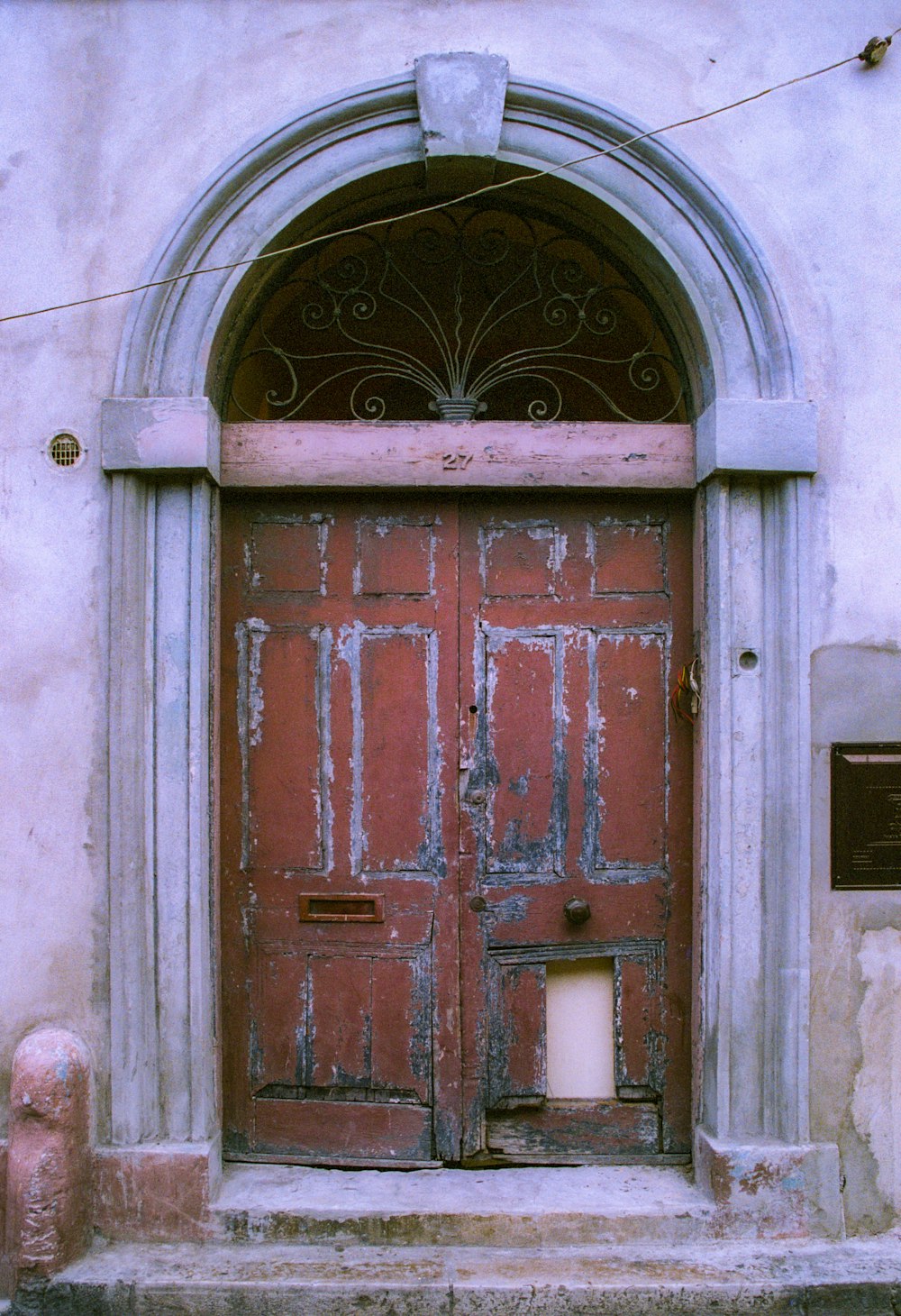 a red door with a candle in the middle of it