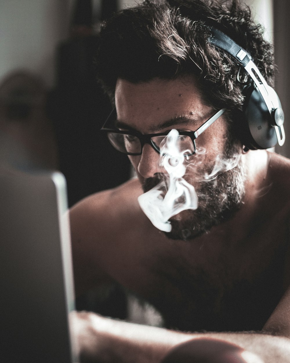 a man wearing headphones and smoking a cigarette
