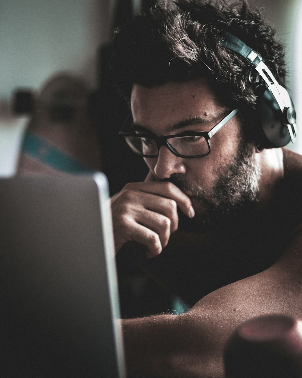 a man wearing headphones looking at a laptop