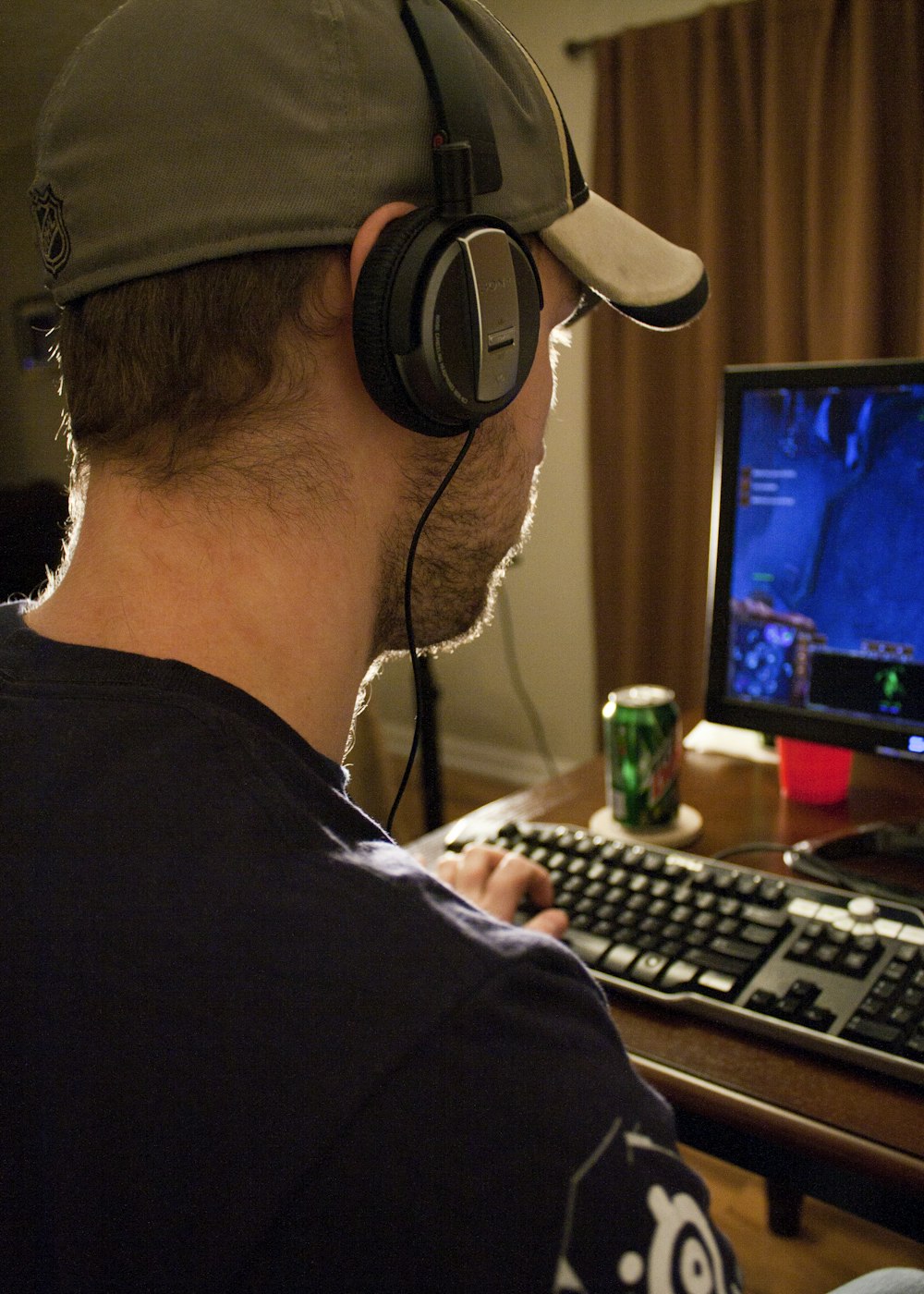 a man sitting in front of a computer with headphones on