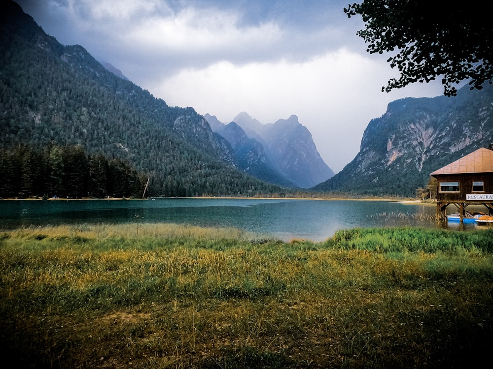 a lake surrounded by mountains with a dock in the foreground