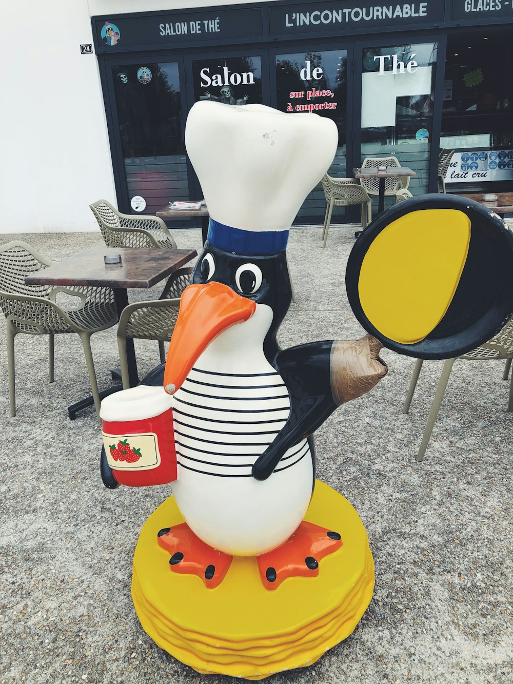 a statue of a penguin with a chef's hat on it's head