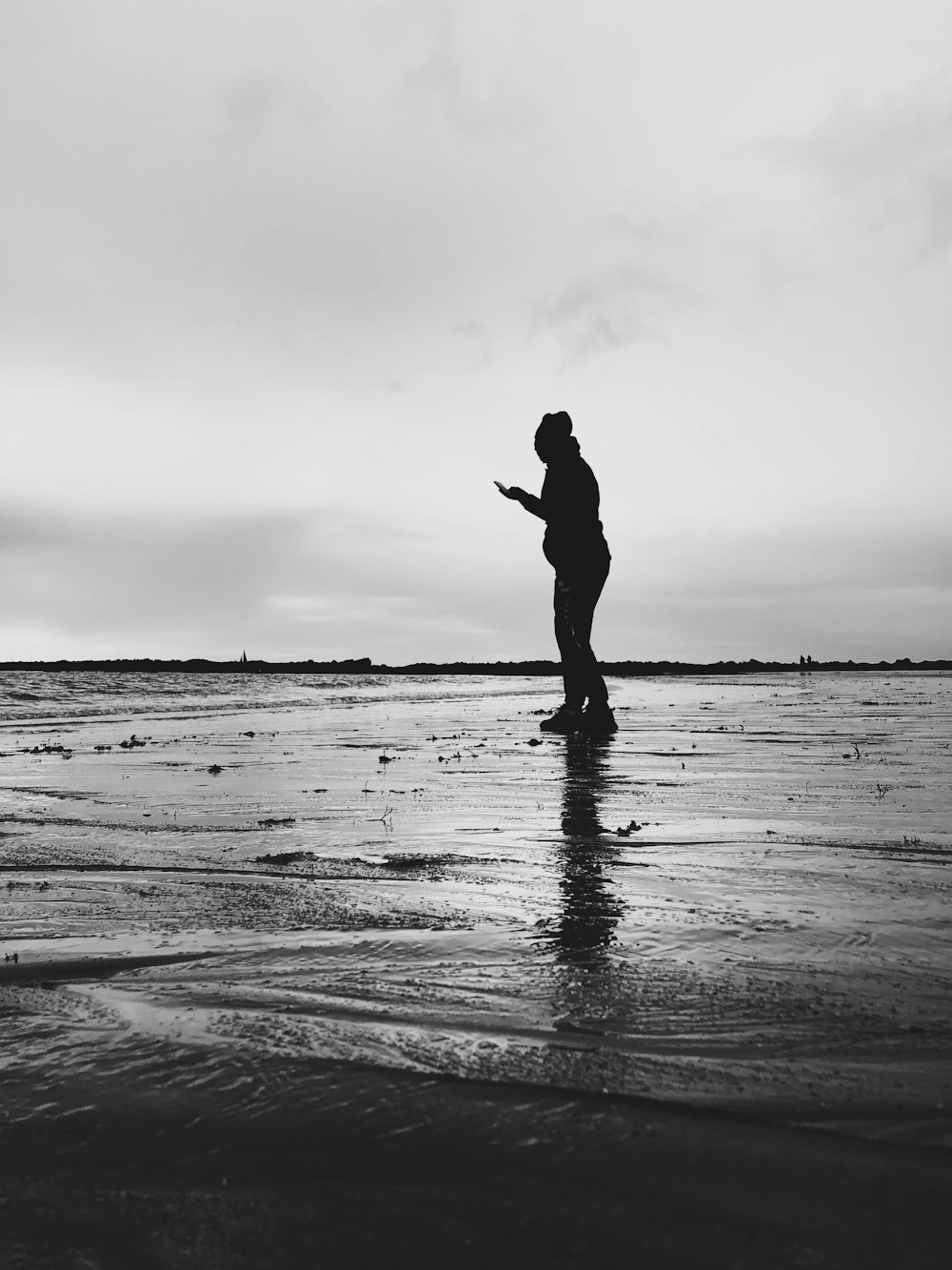 a black and white photo of a person on a beach