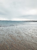 a person walking on the beach with a surfboard
