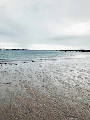 a person walking on the beach with a surfboard