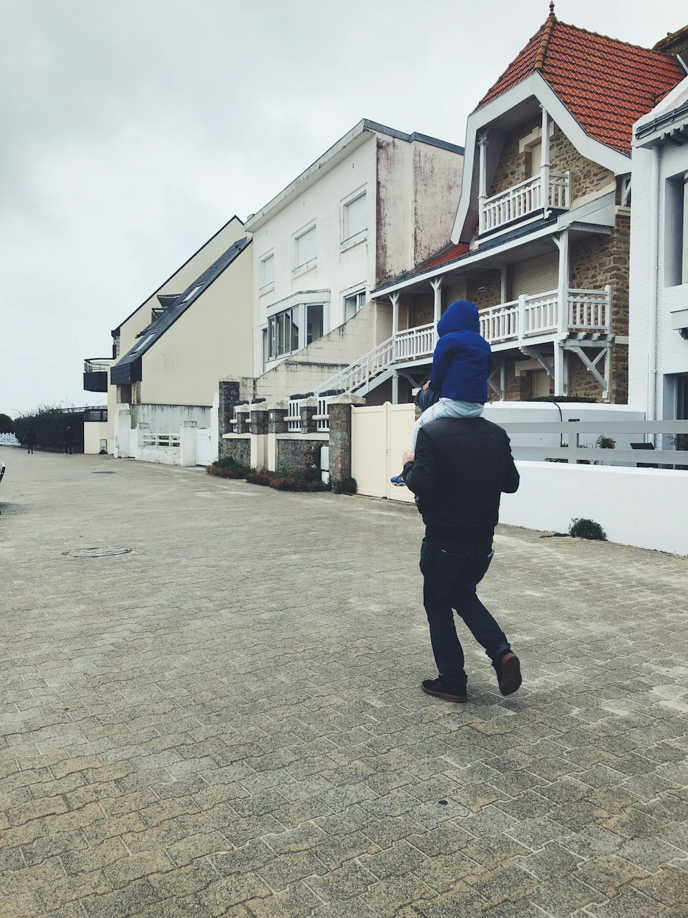 a man in a blue hat walking down a street