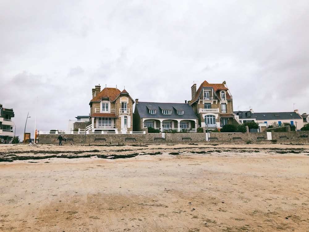 a large house sitting on top of a sandy beach