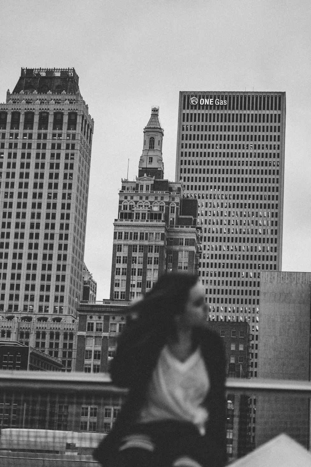 a black and white photo of a woman in a city