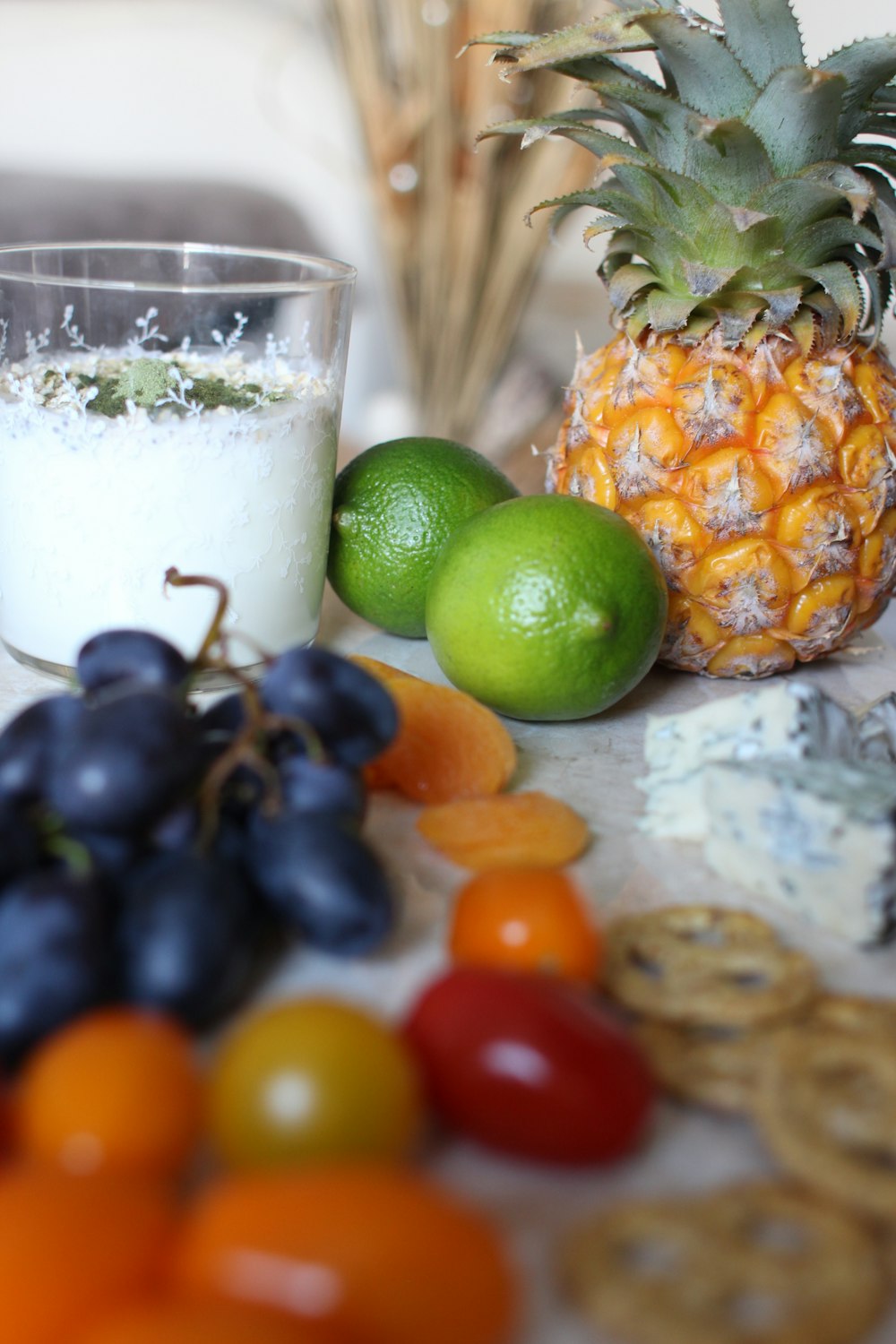 a table topped with a glass of milk next to a pile of fruit