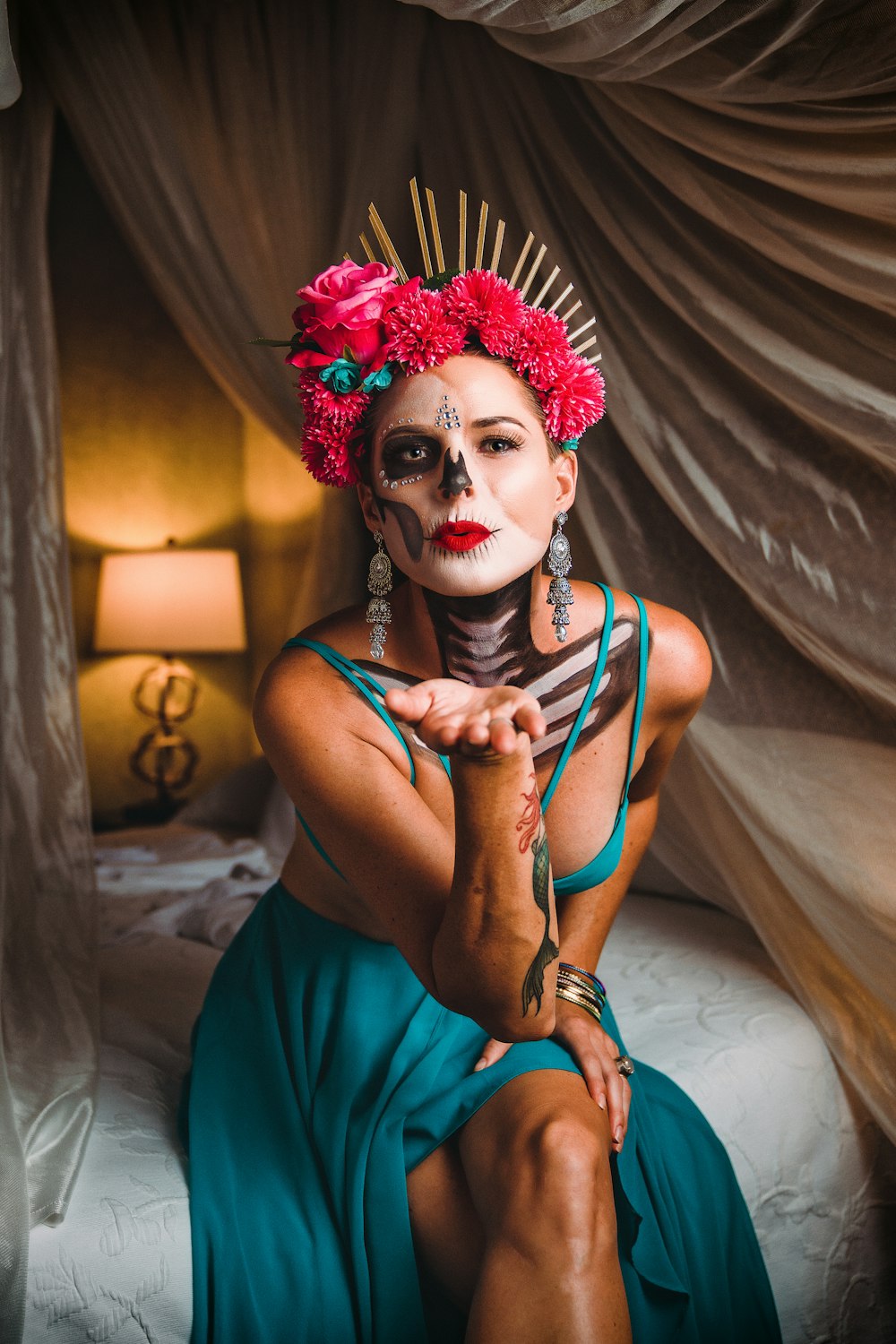 a woman with a skeleton make - up on her face sitting on a bed