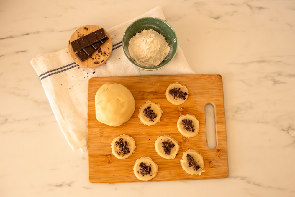 a wooden cutting board topped with pastries on top of a counter