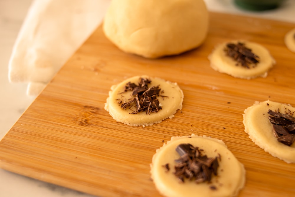 a wooden cutting board topped with cookies on top of a table